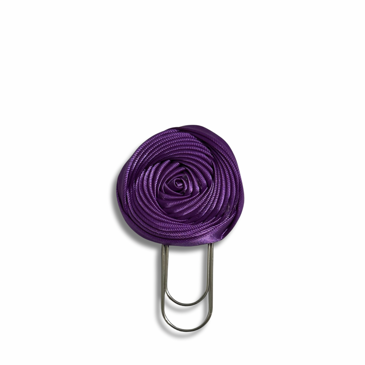 Purple flower-shaped clip on a white background