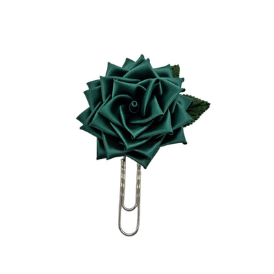 Green rose-shaped paper clip on a white background