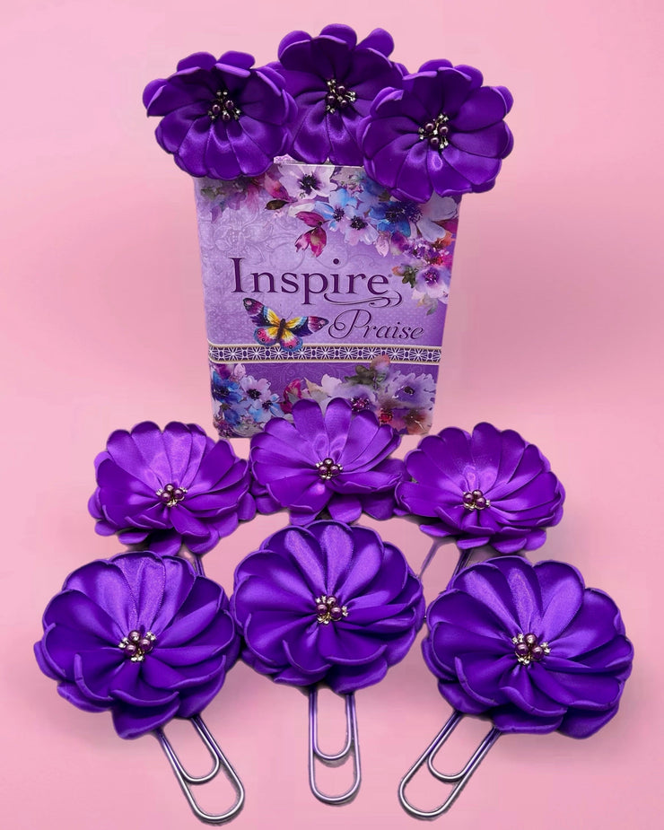 Purple flower-shaped paper clips with a 'Inspire and Pray' container on a pink background